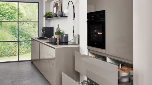 Einbauküche Nobilia® aus Holz in Grau nobilia® Einbauküche Novalux mit Hochglanzfronten und BORA Muldenlüfter Taupegrau & Eiche Como - zweiteilig