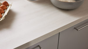 Einbauküche Interliving aus Holz in Hellgrau Interliving Küche Serie 3077 mit Constructa-Einbaugeräten Platingrau & Kiruna Birke - dreizeilig