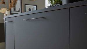 Einbauküche Interliving aus Holz in Schwarz Interliving Küche Serie 3055 mit AEG Einbaugeräten Mattschwarz & Vulkaneiche  - dreizeilig