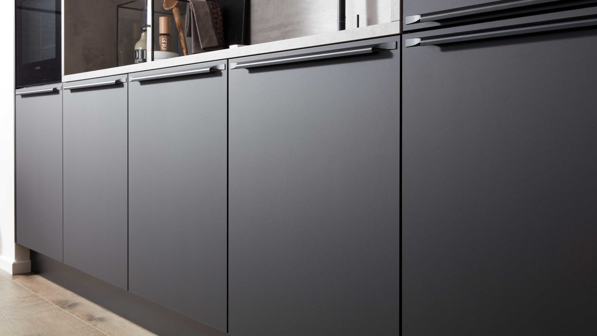 Einbauküche Interliving aus Holz in Schwarz Interliving Küche Serie 3047 mit SIEMENS Einbaugeräten Schwarz & Beton  – zweizeilig