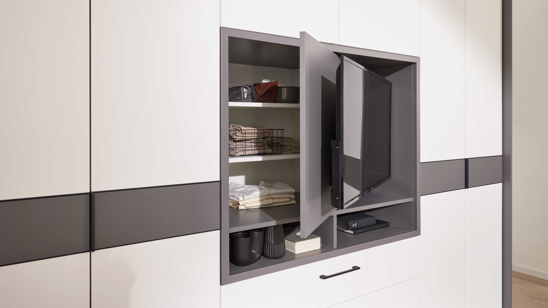 Kleiderschrank Interliving aus Holz in Grau Interliving Kleiderschrank Serie 1207 – Kleiderschrank mit TV-Nische Weiß & Manhattan – sechs Türen, zwei Schubladen, Breite ca. 302 cm